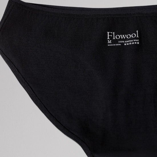Black underwear with 'Flowool' brand label on a light gray background