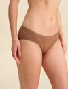 Person wearing a cinnamon bikini brief against a neutral background
