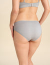 Back view of person wearing grey bikini brief against a neutral background