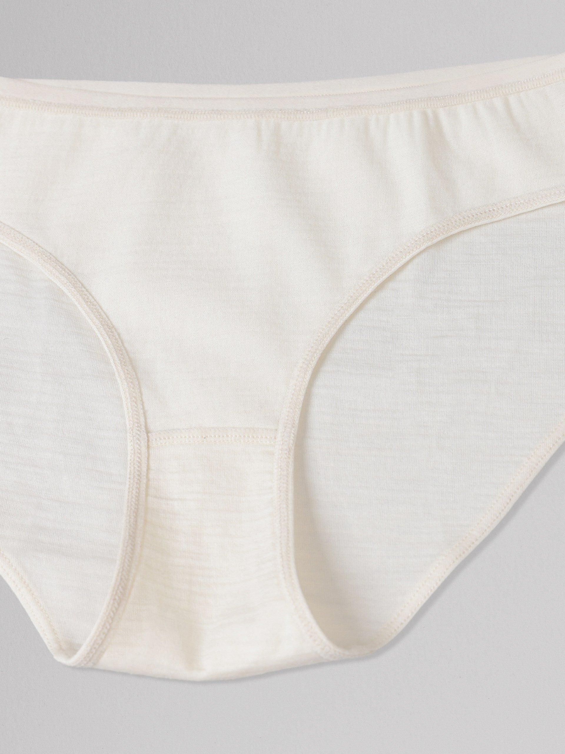 Close-up of off white women's underwear on a light gray background