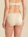 Back view of person wearing sand bikini brief against a neutral background.