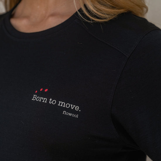 Black t-shirt with 'Born to move' text and red heart design on a blurred background