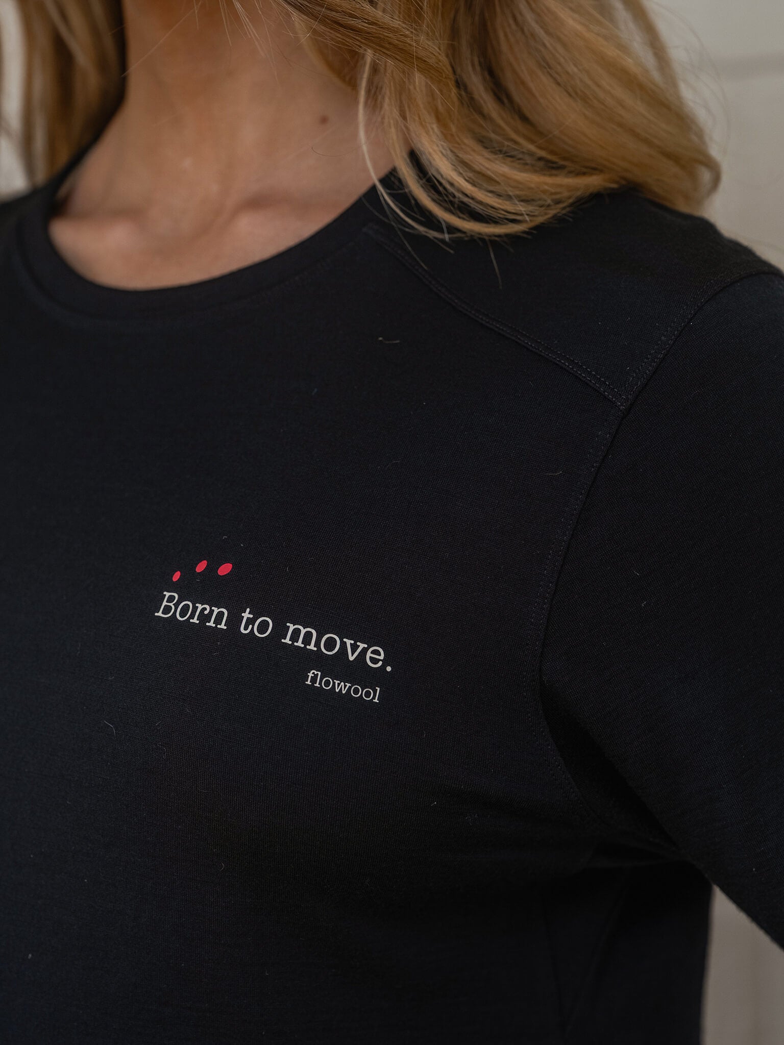 Black t-shirt with 'Born to move' text and red heart design on a blurred background