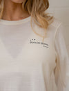 White long-sleeve shirt with 'Born to move' text on a neutral background