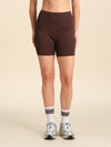 Person wearing chocolate flex sports shorts against a neutral background.