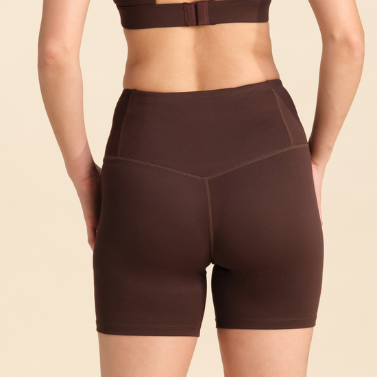 Back view of person wearing chocolate flex sports shorts against a neutral background.