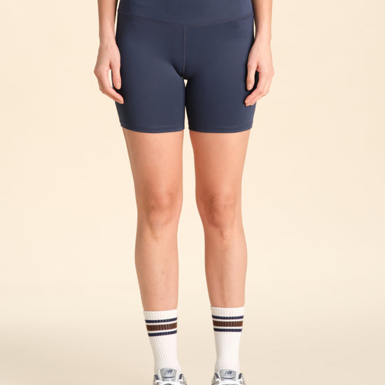 Person wearing navy flex sports shorts against a neutral background.