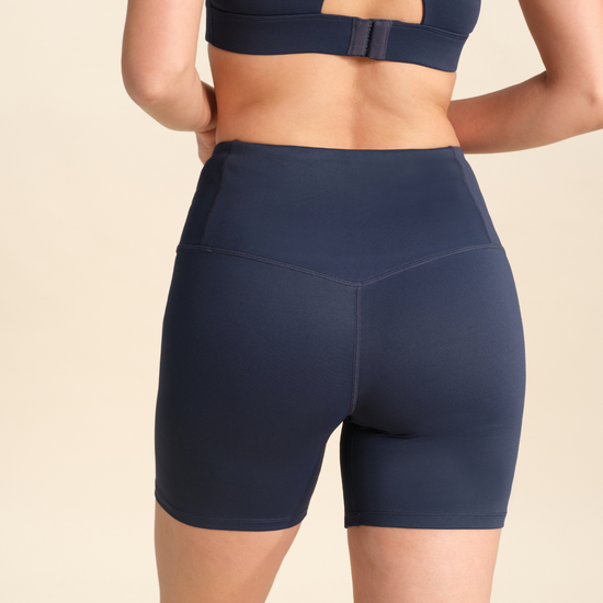 Back view of person wearing navy flex sports shorts against a neutral background.