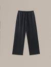 Women's black heather merino wool straight-leg pant on a neutral sand background.
