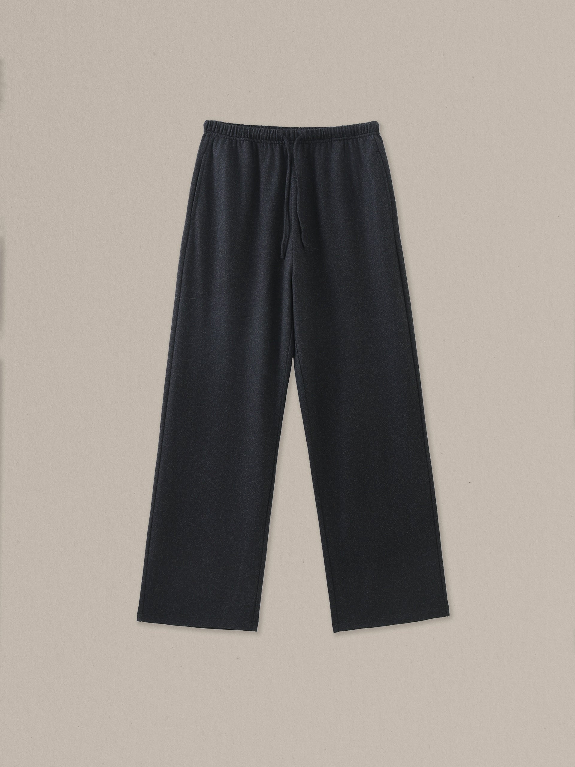 Women's black heather merino wool straight-leg pant on a neutral sand background.