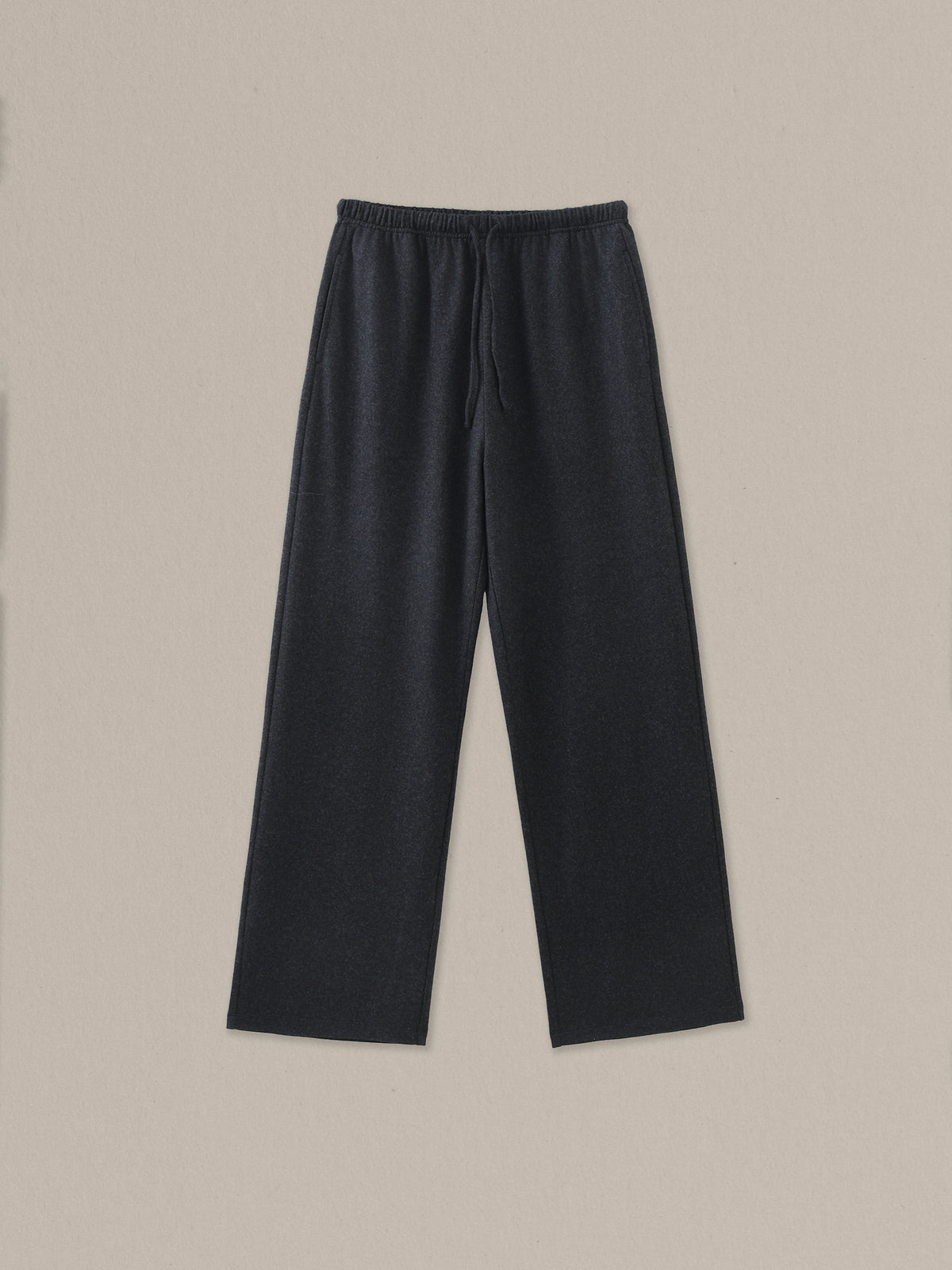 Women's black heather merino wool straight-leg pant on a neutral sand background.
