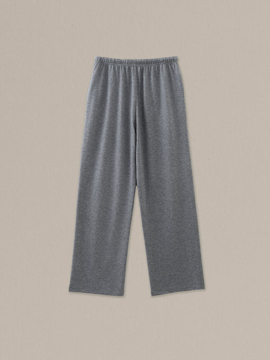 Back view of women's grey heather merino wool straight-leg pant on a neutral sand background.