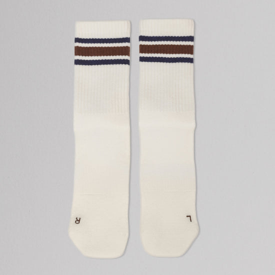 Two white socks with brown and blue stripes on a gray background