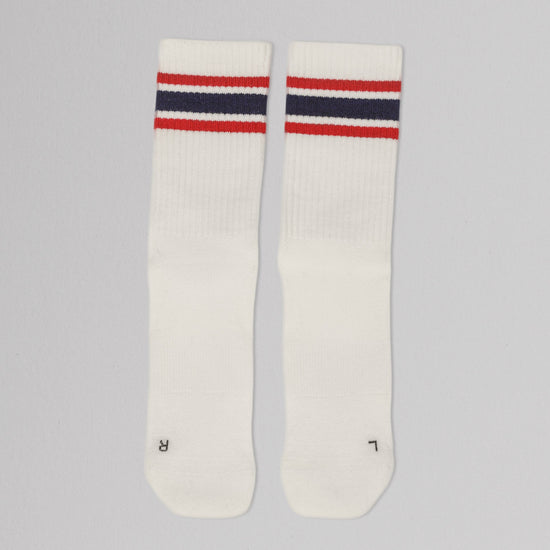 Pair of white socks with red and blue stripes on a gray background