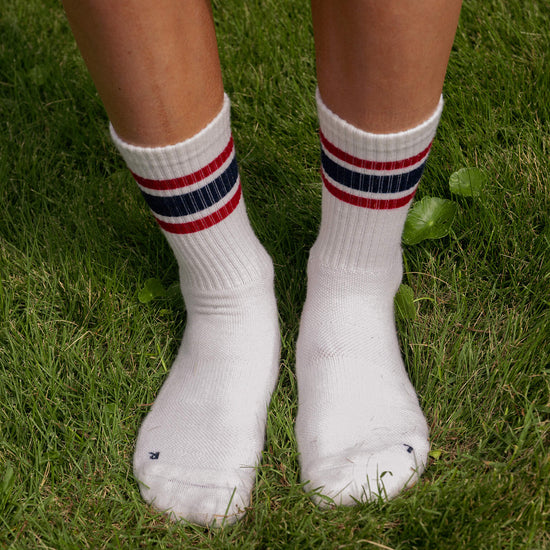 White socks with red and blue stripes worn on grass