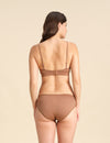 Back view of woman wearing a cinnamon Merino wool triangle bra and underwear set against the background.