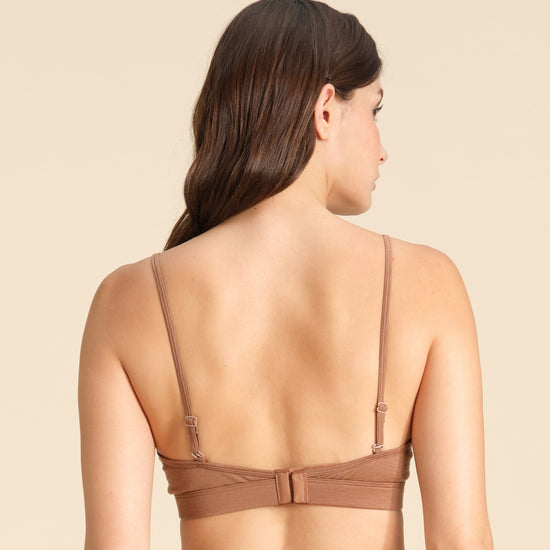Back view of woman wearing a cinnamon Merino wool triangle bra  against the background.