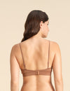 Back view of woman wearing a cinnamon Merino wool triangle bra  against the background.