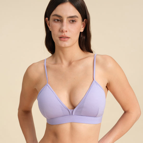 Woman wearing a lavender Merino wool triangle bra against the background.