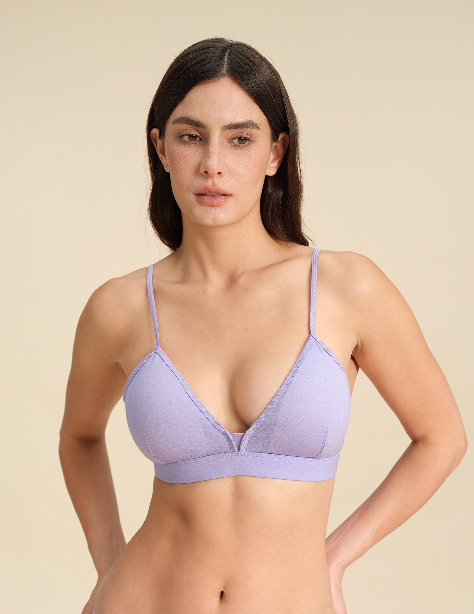 Woman wearing a lavender Merino wool triangle bra against the background.
