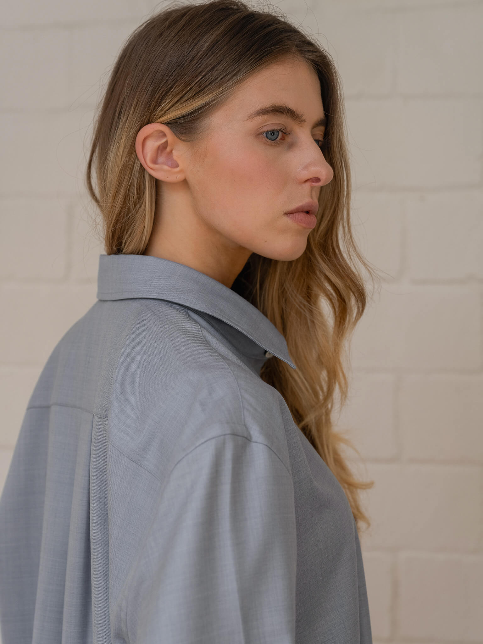 Woman wearing a light blue shirt against a neutral background